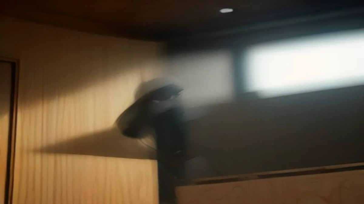 slight low angle of a quality inspector in a clean facility holding a magnifier over a manufactured part, used as the opening image